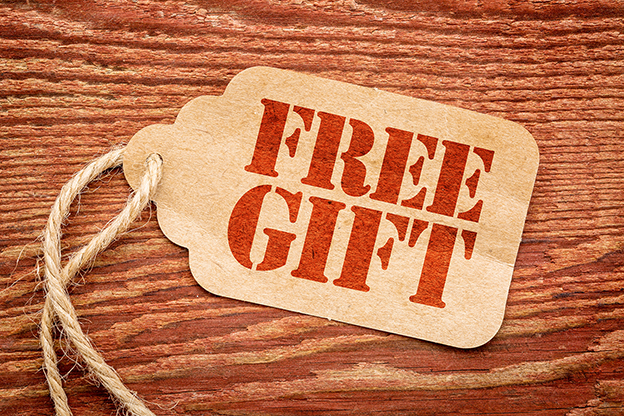 free gift sign - red stencil text a paper price tag against rustic wood