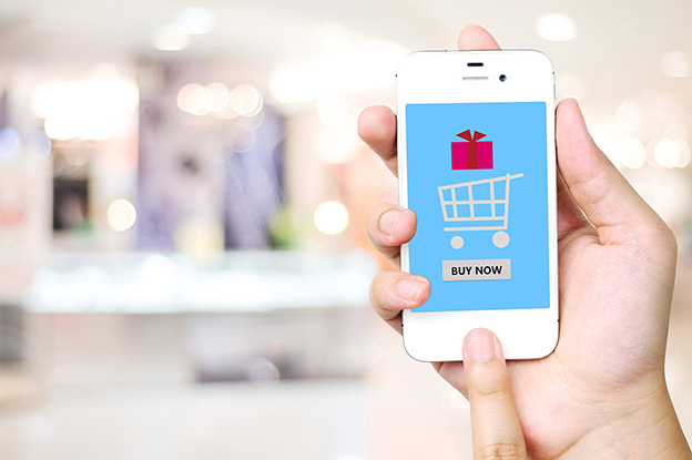 Hand holding smart phone over blur store background, e-commerce, business and technology concept