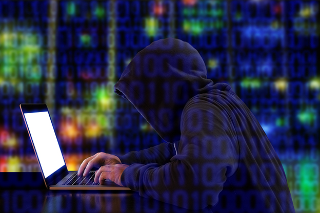 Hacker in a green hoody sitting in front of a notebook with colored server background and binary streams cybersecurity concept