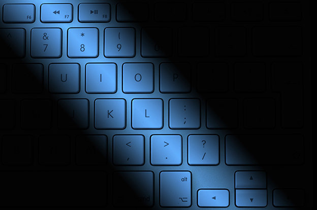 Computer keyboard overlaid with blue lighting and shadows
